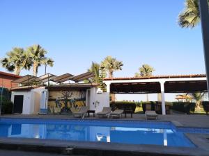a house with a swimming pool and palm trees at Ocean Villa Heights in Brufut