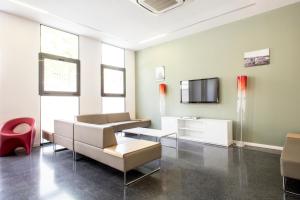 sala de estar con sofá y TV en Alojamientos Universitarios Hipatia en Terrassa