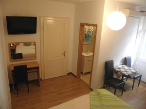 a small room with a desk and a bed and a table at Pansion Sibenik in Šibenik