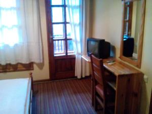 a room with a desk with a television and a bed at Болярска Къща in Arbanasi