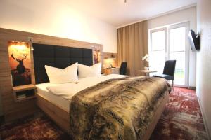 バート・ハルツブルクにあるWellness & Ayurveda Hotel Am Eichenbergの大きなベッドと窓が備わるホテルルームです。