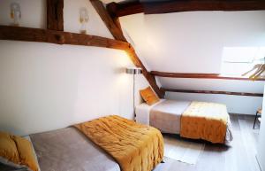 a small bedroom with two beds and a lamp at Ancien moulin Créancey in Créancey