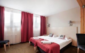 斯托尼拉斯奇的住宿－Karczma Czarna Góra - Czarna Góra Resort，酒店客房,设有两张床和红色窗帘