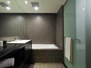台北的住宿－富驛時尚酒店- 南京東路館，带浴缸和盥洗盆的浴室