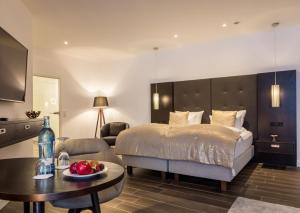 a bedroom with a bed and a living room with a table at Romantik Hotel Schwanefeld & Spa in Meerane