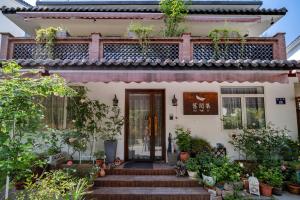 杭州市にあるHangzhou JiuYueJi Bed&Breakfastの階段と植物が目の前にある家