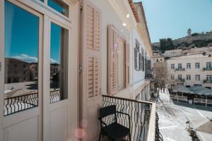 a balcony with a chair looking out at the city at Castellano Hotel & Suites in Nafplio
