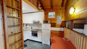 cocina con electrodomésticos blancos y paredes de madera en Tschuggen 61 en Blatten bei Naters