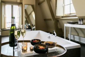 
a counter top with a bowl of food and a glass of wine at Brasss Hotel Suites in Haarlem

