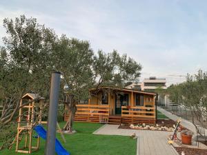 una pequeña casa con parque infantil en un patio en Kamp Karla & Bruno, en Sveti Filip i Jakov