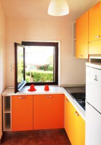 a kitchen with orange cabinets and a window at Residence La Giungla in Falerna