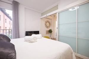 a bedroom with a white bed and a glass door at Apartment SAN MIGUEL in Madrid