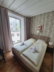 łóżko w sypialni z dużym oknem w obiekcie Pension Seibel w Monachium
