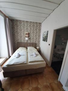 a bedroom with a bed and a bathroom with a sink at Pension Seibel in Munich