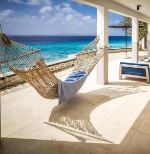 a hammock on a patio overlooking the ocean at Oceanfront 72 & Sunny in Kralendijk