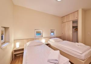 um quarto de hospital com duas camas e duas janelas em Haus Scharhoern_Riff _ Fewo 15 em Cuxhaven