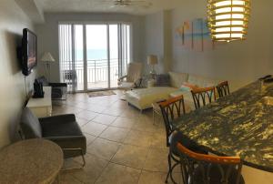 sala de estar con mesa y sofá en Ocean Walk Resort 603, en Daytona Beach