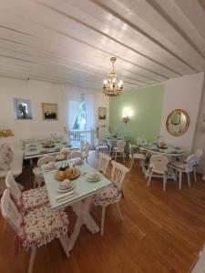 ein Esszimmer mit Tischen, Stühlen und einem Kronleuchter in der Unterkunft Pension Seibel in München