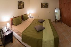 um quarto com uma cama grande e um espelho em Village Villas em Lygia
