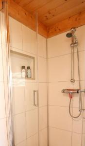 La salle de bains est pourvue d'une douche avec du carrelage blanc. dans l'établissement TinyStay Veluwe, à Otterlo