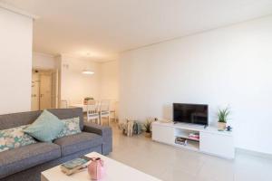 salon z kanapą i telewizorem w obiekcie TGH Málaga we love the sea w Maladze