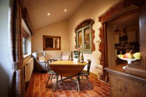 a kitchen and dining room with a table and chairs at Romantic Cottage with Wood-fired Hot tub and Outdoor Pizza Oven in Shrewsbury