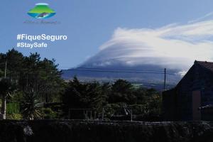 un nuage dans le ciel avec logo aethopoulos segovia dans l'établissement Casas Alto da Bonança, à São Roque do Pico