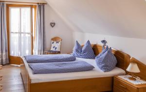 a bedroom with two beds with blue and white pillows at Weingut & Buschenschank Pölzl in Großklein