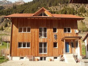 ein Holzhaus mit einem Berg im Hintergrund in der Unterkunft Ferienwohnung Gästehaus Fürlauwi in Meien