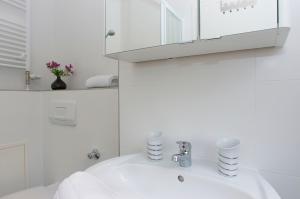 Un baño blanco con lavabo y espejo. en New Green Apartments, en Berlín 32 fotos más