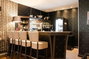 eine Bar in einem Restaurant mit Barhockern in der Unterkunft Hotel Luisenpark in Bad Bergzabern