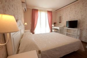 een hotelkamer met een bed en een televisie bij Villa Artemis in Barbati