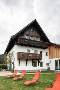 a group of chairs in front of a house at Haus Enzian in Hinterstoder