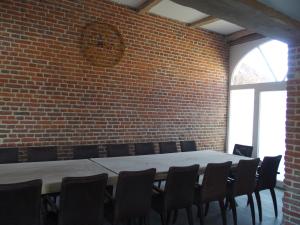 Zimmer mit Ziegelwand, Tisch und Stühlen in der Unterkunft Anc. Seigneurie de Boucaut in Leuze-en-Hainaut