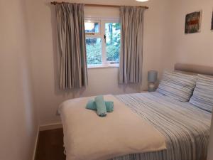 a bedroom with a bed with a blue towel on it at Woodland Retreat in Uny Lelant