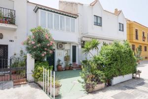 une maison blanche avec des plantes devant elle dans l'établissement TGH Acogedor Duplex en Málaga, à Malaga