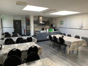 a room with tables and chairs and a kitchen at Pension Moerdijk in Moerdijk