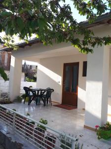 un patio con tavolo e sedie di fronte a una casa di Bona's Home a Tushemisht