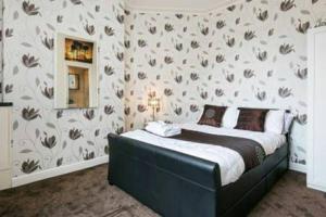 - une chambre avec un lit et un mur orné de fleurs dans l'établissement KNUTSFORD House Holidays, à Manchester