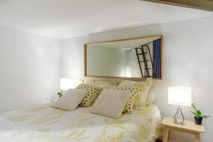 um quarto branco com uma cama com um espelho grande em STYLISH LOFT AT CHUECA´S HEART em Madri