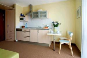 - une cuisine avec une table, un évier et une chaise dans l'établissement Villa Baltic - Apartament Chałupy nr 6, à Chałupy