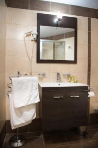 a bathroom with a sink and a mirror at Premier Agrinio Heart Hotel in Agrinion