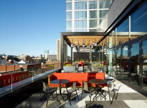 a dining room table with chairs and umbrellas at citizenM Boston North Station in Boston
