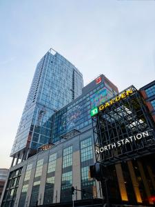 um edifício de vidro alto com uma placa da estação sul. em citizenM Boston North Station em Boston