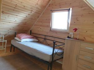 a bedroom with a bed in a log cabin at Idylla in Chłopy