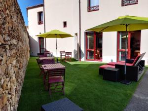 a group of chairs and tables with umbrellas at Hotel La Bosselle in Saint-Philbert-de-Grand-Lieu