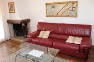 a red leather couch in a living room with a fireplace at Alemanya 9 privat pool in L'Estartit