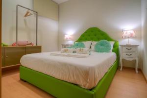 een groene slaapkamer met een groot bed met een groen hoofdeinde bij Port Wine Flats in Vila Nova de Gaia