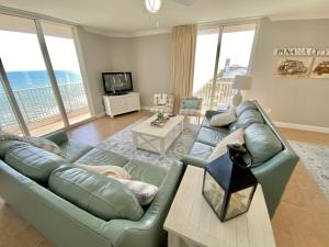 ein Wohnzimmer mit Sofa und Tisch in der Unterkunft Happy Ours 2200 sq ft corner beachfront sleeps 12 in Panama City Beach