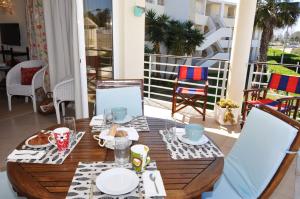 - une table en bois avec de la nourriture sur le balcon dans l'établissement Sunset at Vila da Praia, à Alvor